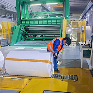 Robust Export Packaging for Safe Container Loading Worker applying moisture-proof export packaging to sublimation paper rolls