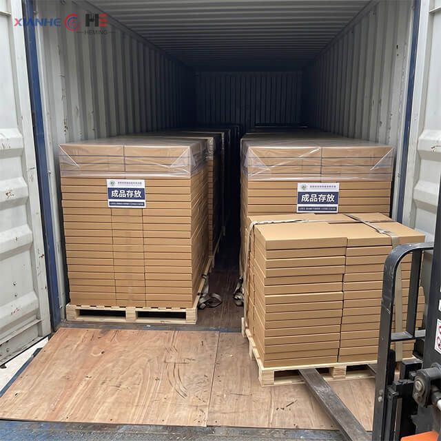 Pallets of wholesale food grade wrapping paper being loaded into a shipping container at the Heming Paper factory