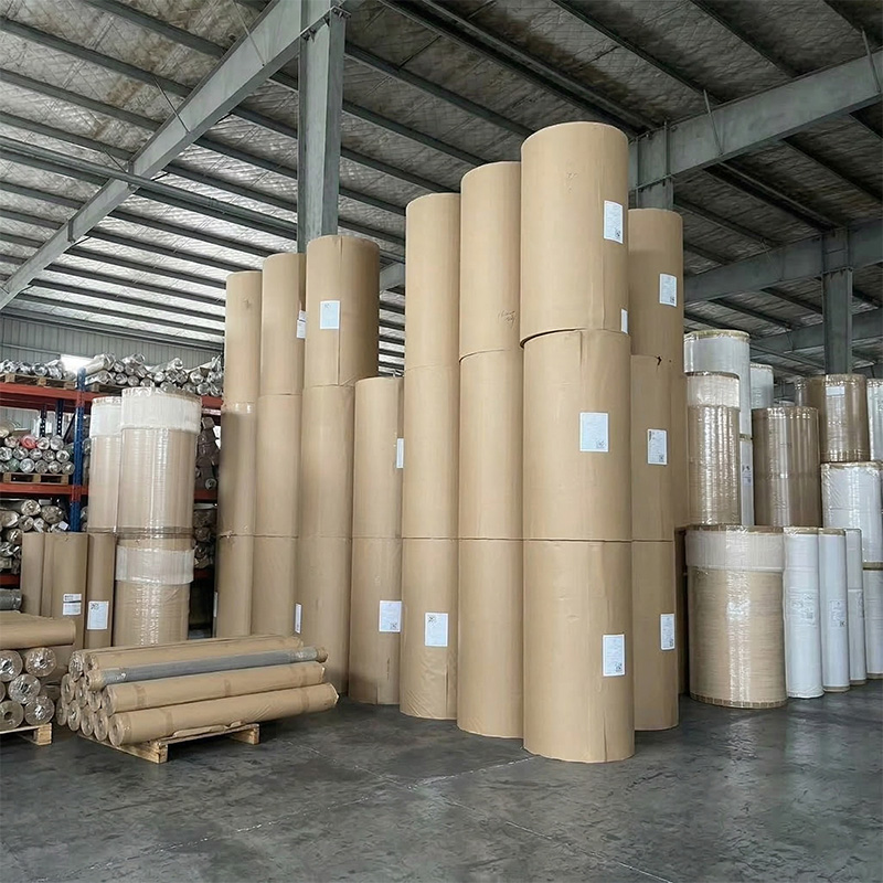 Massive inventory of wholesale sublimation paper jumbo rolls standing vertically in our climate-controlled factory warehouse