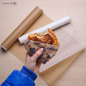 Burger wrapped in printable greaseproof paper next to kraft and white rolls