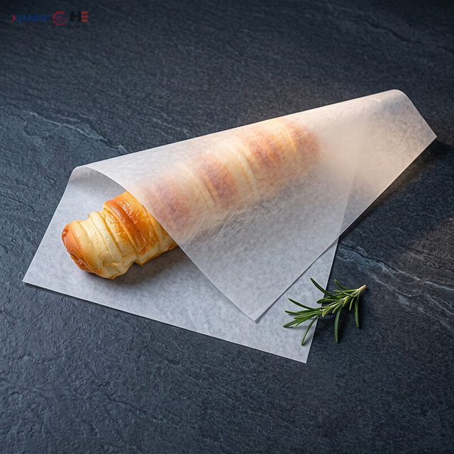 Plain white greaseproof paper sheet wrapped around a baked pastry on a slate board