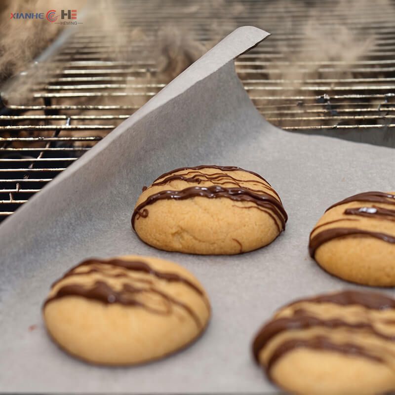 Freshly baked cookies on non-stick baking paper sheet pan liner in commercial oven