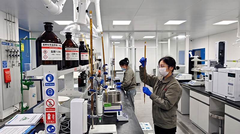 Quality control technicians testing tensile strength moisture and barrier properties in laboratory