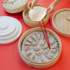 Round parchment steamer paper liner placed in bamboo steamer filled with Chinese dumplings
