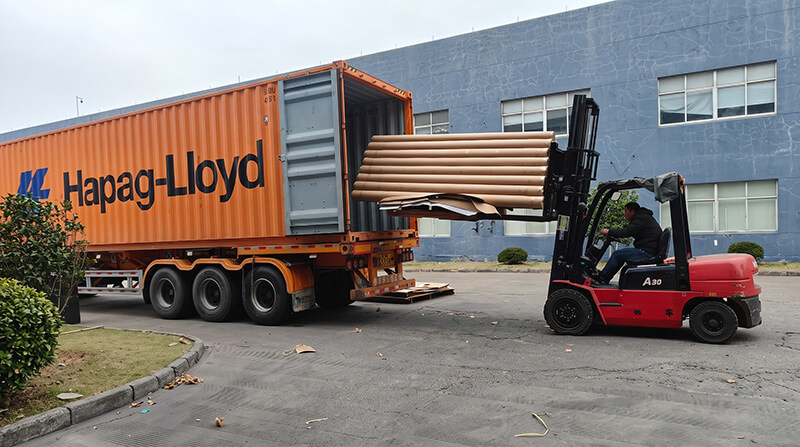 Forklift loading moisture-proof wrapped paper roll pallets into shipping container for export