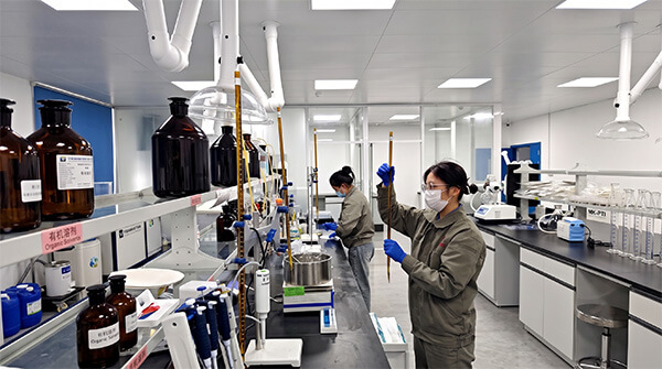 Heming's in-house R&D team researchers discussing capacitor paper formulation and development in the laboratory.