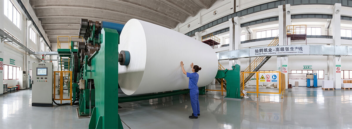 Large scale jumbo base paper roll being inspected at a professional sublimation paper factory.