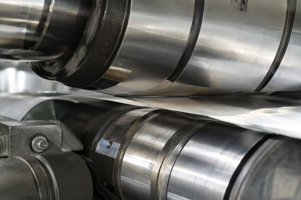 Macro close-up of rotary die cylinder kiss-cutting label stock against a dense glassine anvil liner