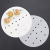 Double-sided silicone coated perforated steamer paper rounds with steamed dim sum siu mai