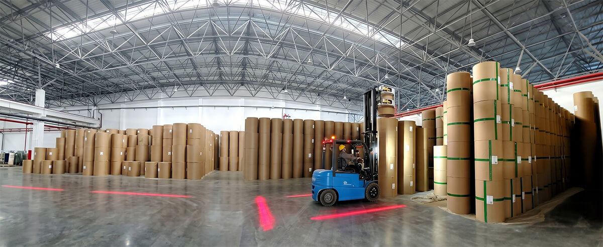 Forklift organizing bulk wholesale sublimation paper rolls in a large industrial warehouse