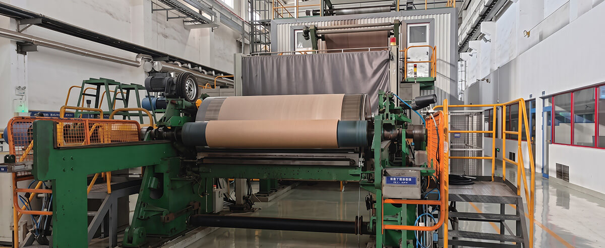 Industrial paper machine winding a jumbo roll of electrolytic capacitor separator paper in a clean factory