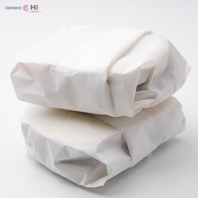 Takeaway burgers wrapped in oil-resistant white greaseproof paper sheets for fast food packaging